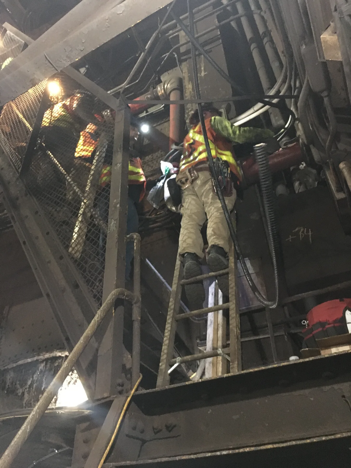 Electrical crew working above a transit tunnel track